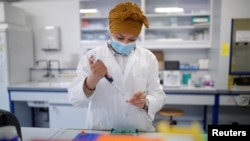 A researcher manipulates proteins in a laboratory as part of a project to develop a COVID-19 nasal spray vaccine at the University of Tours, France, Sept. 15, 2021. 