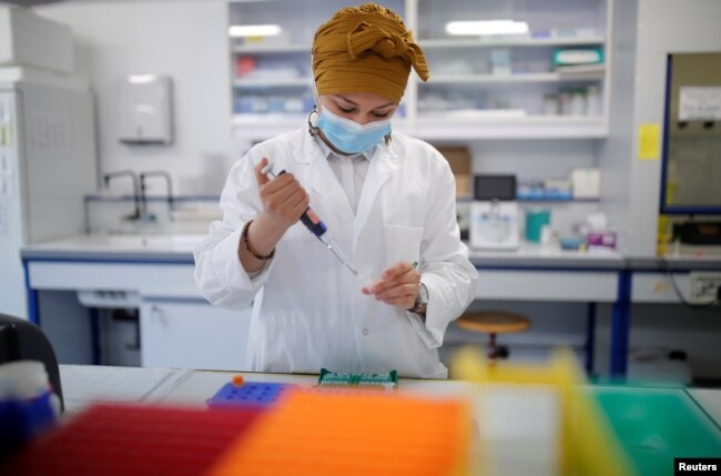 FILE - A researcher manipulates proteins in a laboratory as part of a project to develop a COVID-19 nasal spray vaccine at the University of Tours, France, Sept. 15, 2021. (REUTERS/Stephane Mahe)