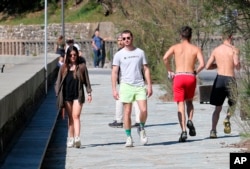 People walks near the beach during a nationwide confinement to prevent the spread of the coronavirus, in Biarritz, France, Saturday April 4, 2020.