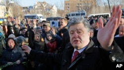 Ukraine's President Petro Poroshenko speaks with people after a wreath laying ceremony at the monument to the fallen Heroes of the "Heavenly Sotnya" (Hundred) in Kiev, Ukraine, Nov. 21, 2014.