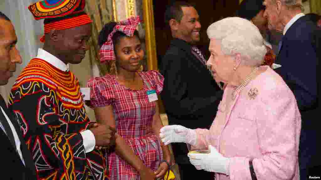 Queen Elizabeth II meets Africa Regional Winner of the Commonwealth Youth Awards Achaleke Christian Leke (L) and Caribbean Regional Winner Shamoy Hajare (C) at the annual Commonwealth Day reception at Marlborough House in London, March 14, 2016.&nbsp;