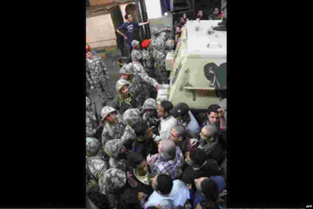 Egyptian soldiers, left, are unsuccessful as they try to stop angry protesters who storm the state security building headquarters in Cairo's northern Nasr City neighborhood, Egypt, Saturday, March 5, 2011.