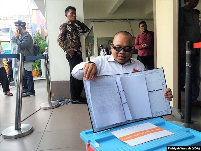 Koordinator Relawan IT BPN Mustofa Nahrawardaya memperlihatkan barang bukti terkait kecurangan hasil verifikasi data aplikasi penghitungan suara (Situng) Komisi Pemilihan Umum (KPU) di Jakarta, Jumat, 3 Mei 2019. (Foto: Fathiyah Wardah/VOA)