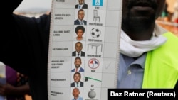 Seorang petugas pemilu menunjukkan surat suara setelah TPS ditutup selama pemilihan presiden di Kampala, Uganda, 14 Januari 2021. (Foto: REUTERS/Baz Ratner)