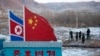FILE - A Chinese-built fence near a concrete marker depicts the North Korean and Chinese national flags with the words "China North Korea Border" at a crossing in the Chinese border town of Tumen in eastern China's Jilin province. 