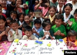 Tibetan children gather around a cake during a function organized to mark the 82nd birthday celebration of the Dalai Lama in Lalitpur, Nepal, July 6, 2017.