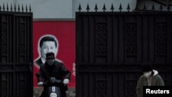 在上海，习近平画像前带口罩的人（2020年2月10日）