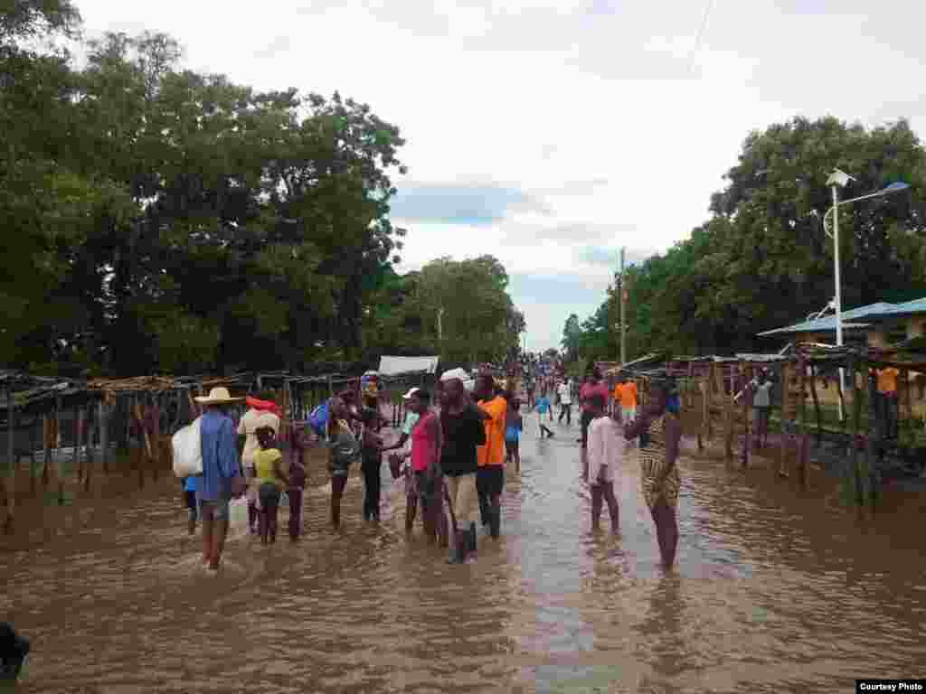 People stand in a flooded street that usually serves as a farmers market, in Ouanaminthe, northeast Haiti, Sept. 8, 2017. (Photo - Josiah Cherenfant, courtesy VOA Creole Service)