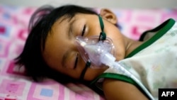 A boy with dengue fever receives medical oxygen while laying on a bed at the Quirino hospital in Quezon city in the suburbs of Manila, August 14, 2012.