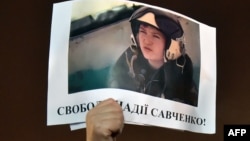 A demonstrator holds a picture of Ukranian army officer captured by pro-Russian insurgents, Nadiya Savchenko, bearing the slogan "Free Nadiya Savchenko" during a rally on Independence Square in Kiev on Jan. 26, 2015.