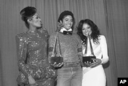 Michael Jackson is flanked by Singer Bonnie Pointer, left, and his sister Latoya, right, at the American Music Awards in Los Angeles, Jan. 31, 1981. Jackson won two awards for favorite soul album "Off the Wall" and favorite male soul vocalist.