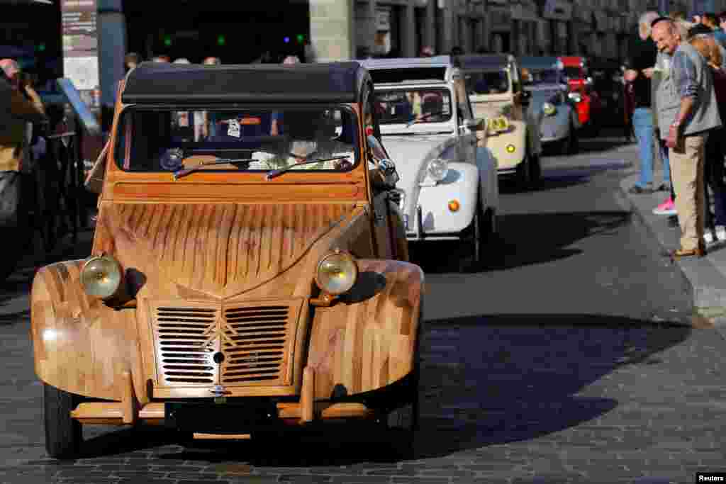 Michel Robillard, mendesain badan mobil kunonya 2CV Citroen dengan struktur dari kayu, dalam parade di Loches, Perancis.