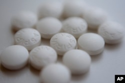 Aspirin pills are arranged on a counter in New York, Aug. 23, 2018.