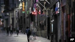 Njerëzit ecin në rrugët me baret e mbyllura në qytetin Liverpool (14 tetor 2020)