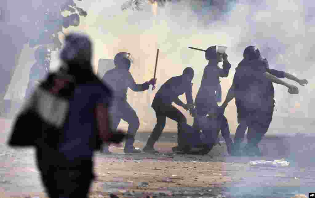 Polisi menangkap dan memukuli seorang demonstran.