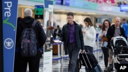 Sejumlah penumpang mengantre di Terminal 1 Bandara Internasional O'Hare di Chicago, pada 21 November 2023, di mana banyak dari mereka mudik untuk memperingati Thanksgiving. (Foto: AP/Erin Hooley)