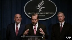 Human Services Secretary Alex Azar speaks as Centers for Disease Control and Prevention (CDC) director, Robert R. Redfield, left, and Deputy Secretary of State Stephen Biegun listen during a press conference, Feb. 7, 2020 in Washington.