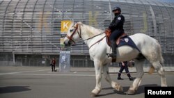 FILE - A French policeman patrols on a horse during a mock chemical attack drill at the Pierre Mauroy stadium in Villeneuve d'Ascq, France, April 21, 2016, in preparation of security measures for the 2016 European soccer championship.