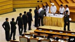 Para anggota parlemen Myanmar melakukan voting untuk menolak RUU yang akan mengakhiri hak veto efektif militer atas amandemen konstitusi, di Naypyitaw, Myanmar, hari Kamis (25/6).