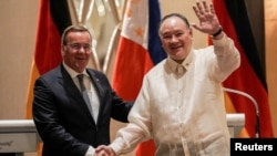 Menteri Pertahanan Jerman Boris Pistorius (kiri) berjabat tangan dengan Menteri Pertahanan Filipina Gilberto Teodoro usai konferensi pers bersama di Makati, Metro Manila, Minggu (4/8). 