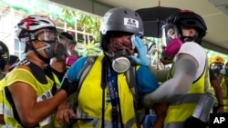 In this Sept. 29, 2019, photo, Indonesian video journalist Veby Mega Indah, center, is attended to in Hong Kong after being hit in the eye by what she believes was a projectile fired by riot police.