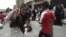 FILE - A man carries food aid provided by the Red Crescent Society in Sana'a.