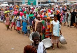 People wait to receive food and water in Accra, Ghana, during a partial lockdown to slow the spread of the coronavirus disease (COVID-19), April 4, 2020.