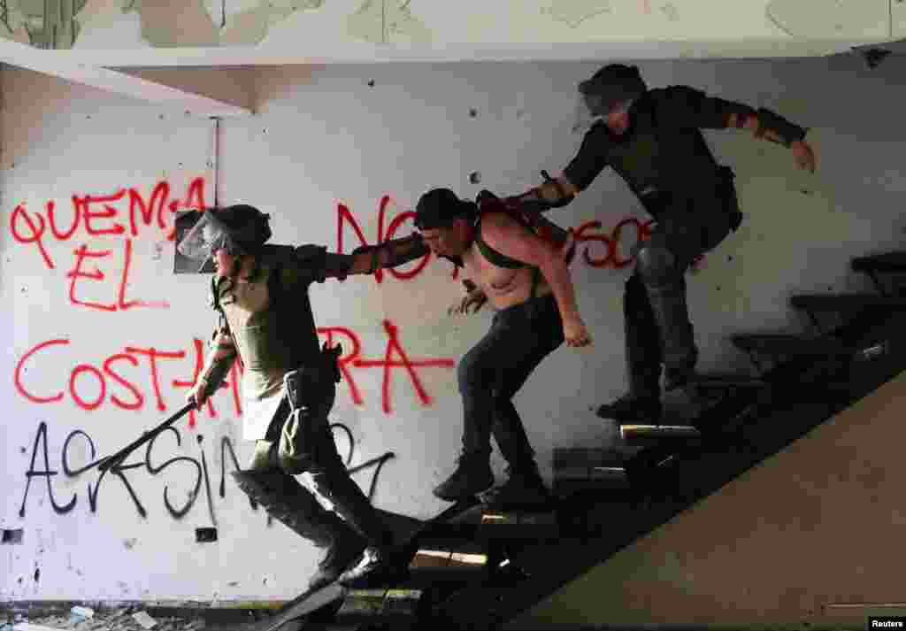 Members of the security forces detain a demonstrator during a protest against Chile's government in Santiago, Nov. 27, 2019.