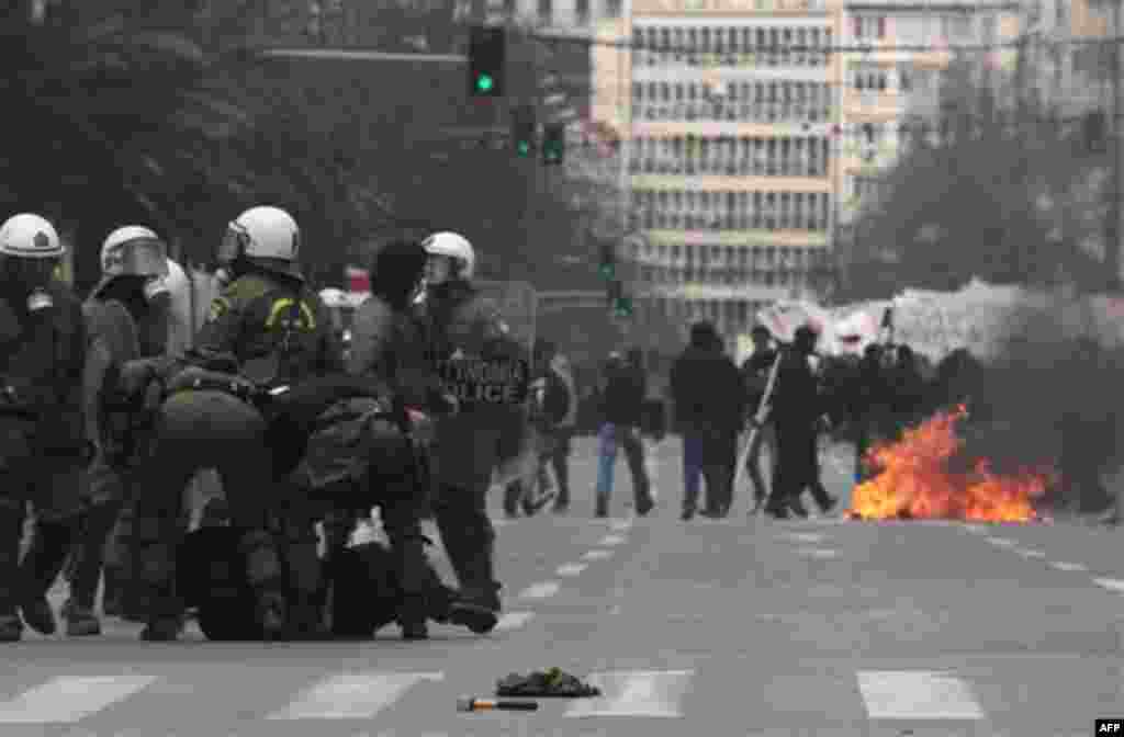 Riot police detain a protester during clashes in central Athens on Wednesday, Feb. 23, 2011. Scores of youths hurled rocks and petrol bombs at riot police after clashes broke out Wednesday during a mass rally taking place as part of a general strike. (AP