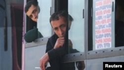 Refugees from the Nagorno-Karabakh region of Azerbaijan sit in a bus upon their arrival in the border village of Kornidzor, Armenia, on Sept. 29, 2023. 