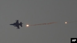 FILE - An Israeli fighter jet releases flares as it flies over the Gaza Strip, as seen from southern Israel, January 16, 2024.