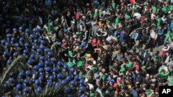 Protesters confront police officers during a demonstration against the country's leadership in Algiers, April 12, 2019.