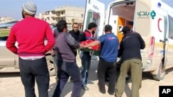 FILE - An injured person is carried on stretcher into an ambulance after an airstrike on location targeted by government and aliied forces, in Khan Sheikhoun, Idlib, Syria, Feb. 26, 2019,