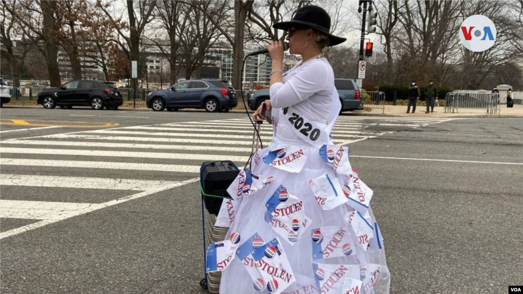 Manifestante viste una falda adornada con papeles que dicen &quot;Robada&quot;, en referencia a las denuncias de supuesto fraude electoral de Trump.