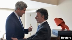 U.S. Secretary of State John Kerry (L) embraces Colombia's President Juan Manuel Santos at his arrival at the presidential palace in Bogota August 12, 2013. Kerry is in Colombia for a one-day visit. REUTERS/Javier Casella/ColombianPresidency/Handout via