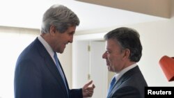 Menlu AS John Kerry (kiri) disambut oleh Presiden Kolombia Juan Manuel Santos setibanya di Istana Presiden Kolombia di Bogota (12/8). 