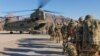 FILE - Soldiers attached to the 101st Resolute Support Sustainment Brigade, Iowa National Guard and 10th Mountain, 2-14 Infantry Battalion load onto a Chinook helicopter to head out on a mission in Afghanistan, Jan. 15, 2019.