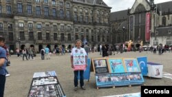 Abdurehim Gheni con fotografías de sus familiares y otros uigures desaparecidos en la plaza Dam de Ámsterdam en julio del 2019.