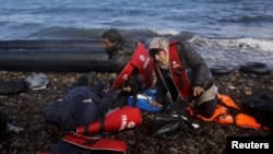 Des réfugiés syriens fatigués, se couchent sur la palge grecque sur lïle de Lesbos, 25 octobre 2015. REUTERS/Yannis Behrakis