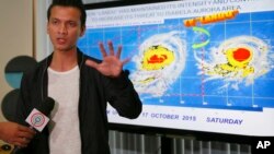 马尼拉东北部的奎松市一名气象预报人员在记者会上向媒体解释台风“巨爵”可能来袭（2015年10月16日）