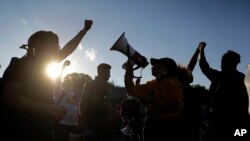 Protesters block a street outside the police station June 10, 2020, in Florissant, Mo. Demonstrators were calling attention to a video that appears to show a Florissant police detective, who has since been fired, striking a man with his police 