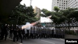 Riot police fire tear gas at demonstrators during a protest against fare hikes for city buses in Sao Paulo, Brazil, Jan. 8, 2016.