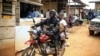 FILE - Motorcycle taxi driver Germain Kalubenge transports a woman whose 5-year-old daughter had a fever and was vomiting to an Ebola transit center where potential cases are evaluated, in Beni, Congo, Aug. 22, 2019. 