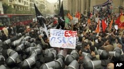 Egyptian anti-riot soldiers surround protesters, with one displaying a "Free Egypt" sign, during a protest against parliamentary elections which they claimed were rigged, Cairo, 12 Dec 2010