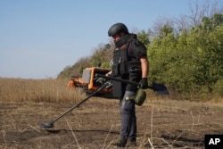 우크라이나 군 병사가 하르키우 전장에서 러시아와의 전투 후 지뢰 제거 작업을 진행하고 잇다.