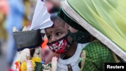 Seorang gadis mengucapkan selamat tinggal kepada patung dewa Hindu Ganesha, dewa kemakmuran, sebelum dilarung di lepas pantai laut Arab saat berlangsungnya festival "Ganesh Chaturthi" di Mumbai, India, 11 September 2021. (REUTERS/Francis Mascarenhas)