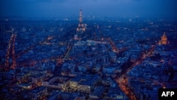 This general view taken from the rooftop of The Tour Montparnasse at twilight on January 8, 2018, shows The Eiffel Tower (C) and The Dome des Invalides (R) in Paris.