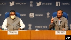 In this Thursday, Feb. 25, 2021, file photo, India's Information Technology Minister Ravi Shankar Prasad, left, and Information and Broadcasting Minister Prakash Javadekar address a press conference announcing new regulations for social media companies.