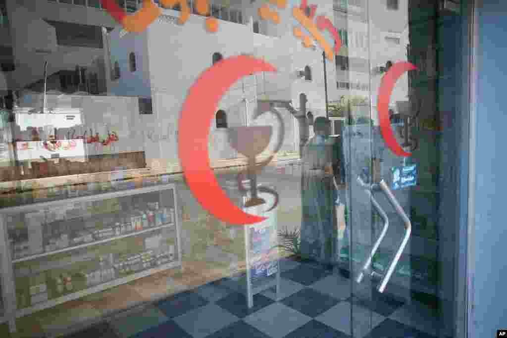 On a block in Tripoli with mostly shuttered storefronts, a pharmacy is open for half an hour a day. (VOA Photo - J. Weeks)