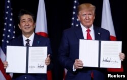 Japan's Prime Minister Shinzo Abe and U.S. President Donald Trump pose with a joint statement the two leaders made during a bilateral meeting on the sidelines of the 74th session of the U.N. General Assembly in New York, Sept. 25, 2019.